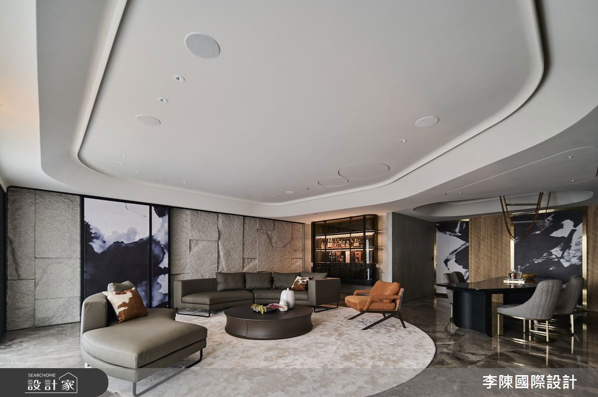 沙發背牆以天然花崗岩石皮打造，透過精密工法，完美融合了粗獷的原始感與充滿科技感的未來氛圍