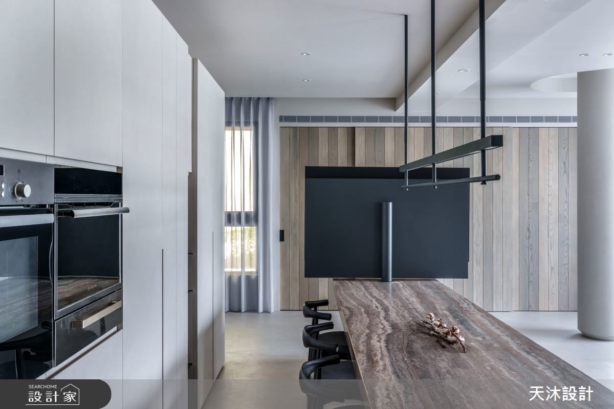 訂製一張大尺寸餐桌結合中島，洞石材質桌面呼應自然材質的應用，將機能與美學完美整合