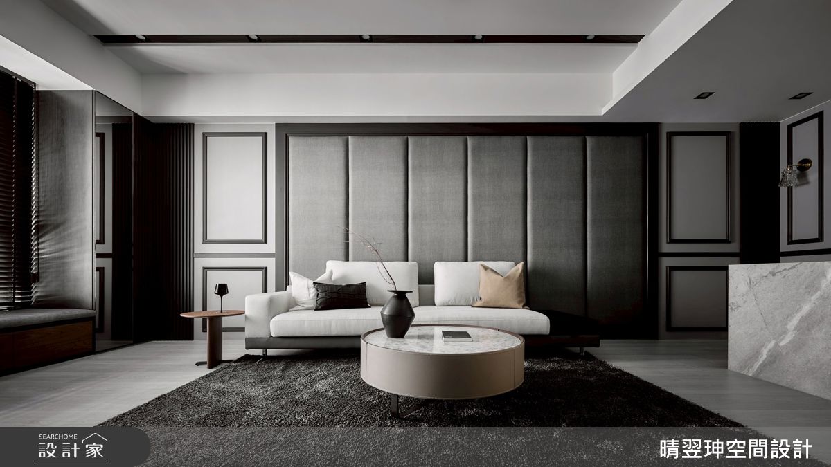 沙發背牆展現古典的對稱美感，同時簡化線條，融入現代簡約的韻致，透過視覺設計平衡上方天花大梁的影響。