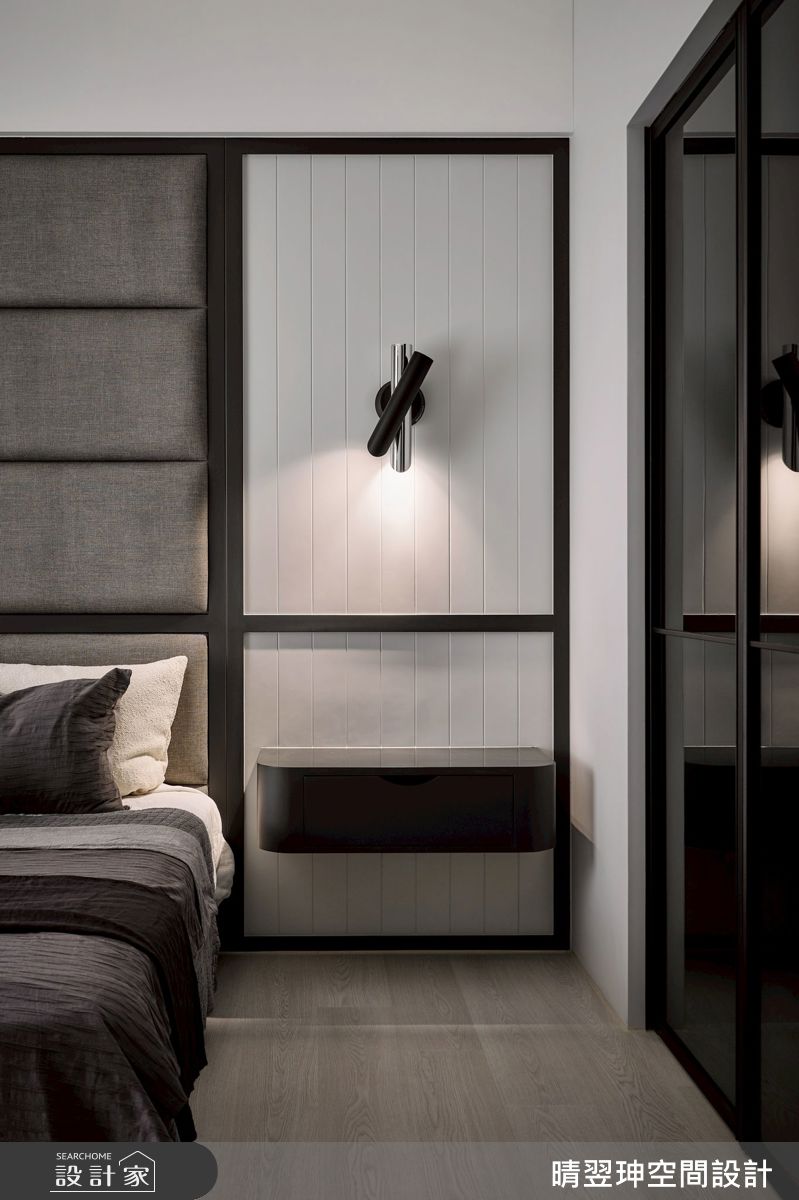 主臥室延續灰階古典簡約之美，對稱線板與繃皮革床頭，搭配柔和壁燈，營造沉靜舒適的休憩環境。