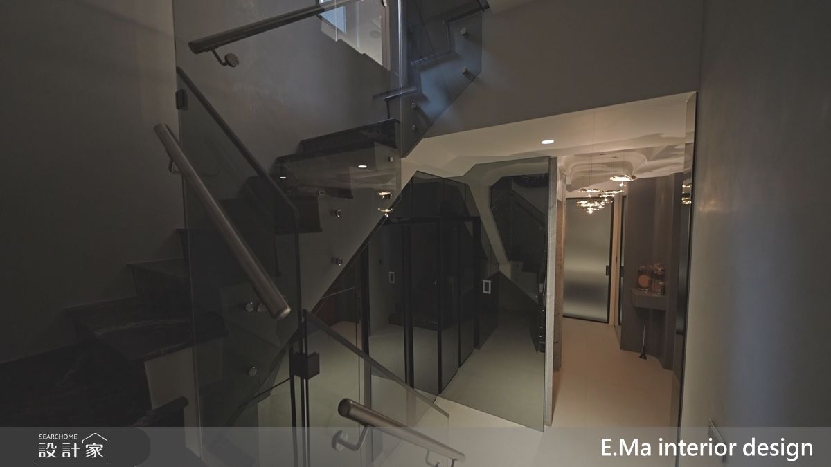 義大利原裝燈具與書法家藝術作品，營造出如藝廊般的玄關層次；玻璃扶手的樓梯則讓上下樓時能相互看見，增加互動。