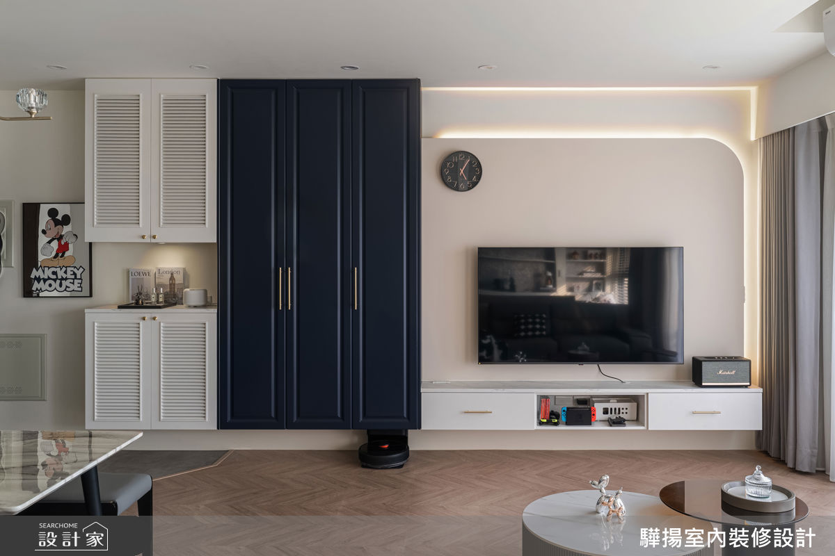 客廳電視牆結合奶油白玄關櫃與靛藍收納櫃,並以圓弧燈帶弱化邊角,體現現代美式風格的精緻度。