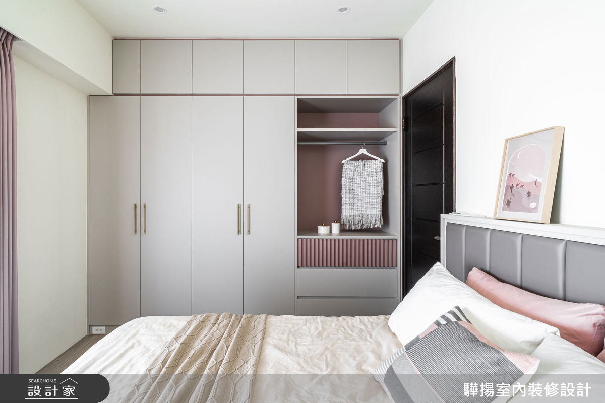 主臥室以灰粉混搭元素妝點,整面衣櫃結合封閉與局部開放設計,讓機能和美感融為一體。