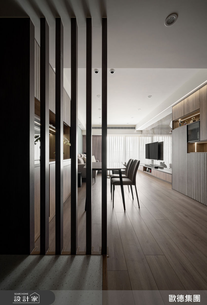 玄關以半開放木格柵屏風引光入室,同時維持隱私與空間穿透。
