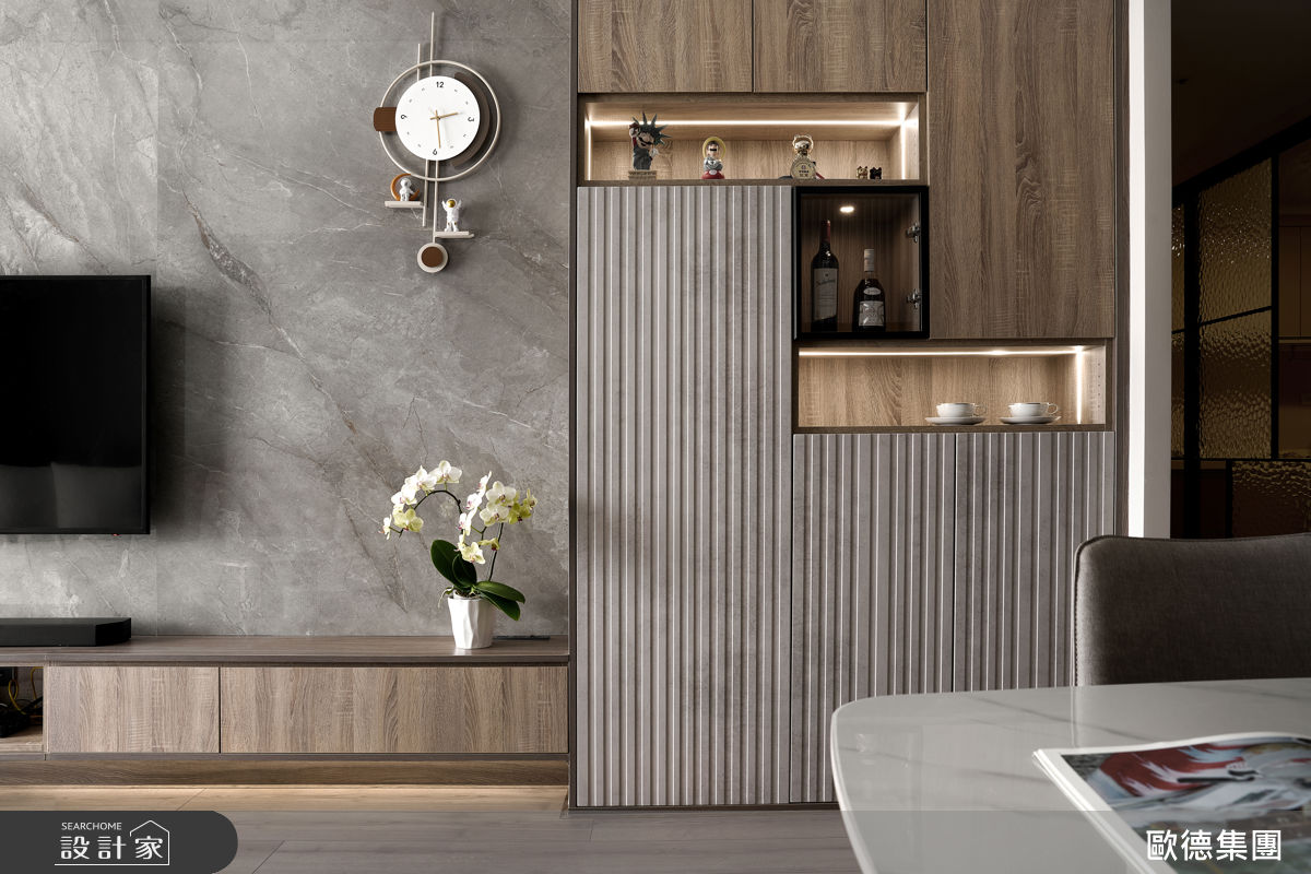 深木紋系統櫃貫穿公領域三面動線,結合鏡面、格柵與燈條設計,消弭厚重感並增添層次。