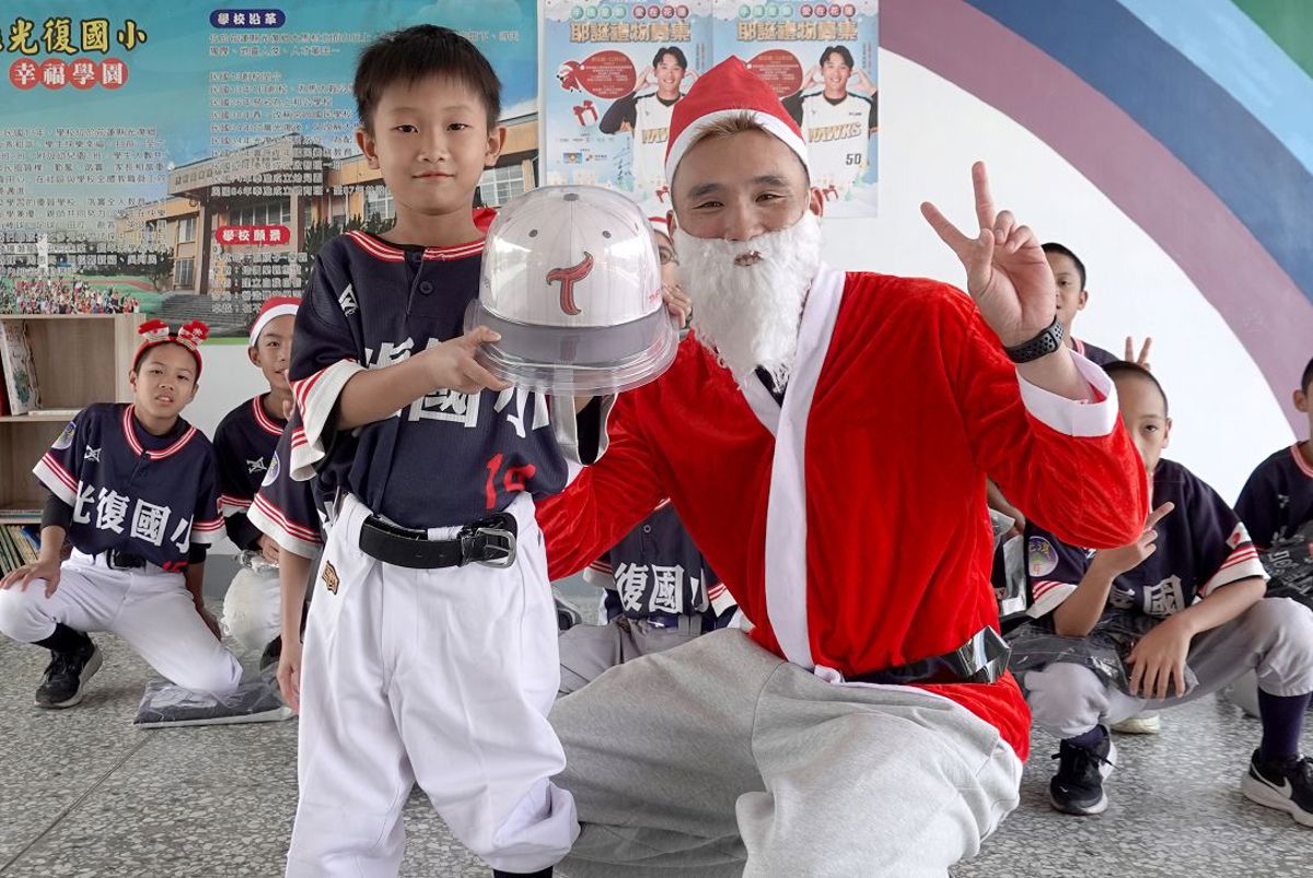 光復國小孩子拿到最開心的禮物，就是獲得歐德集團愛心大使高聖恩(右)簽名帽一頂。