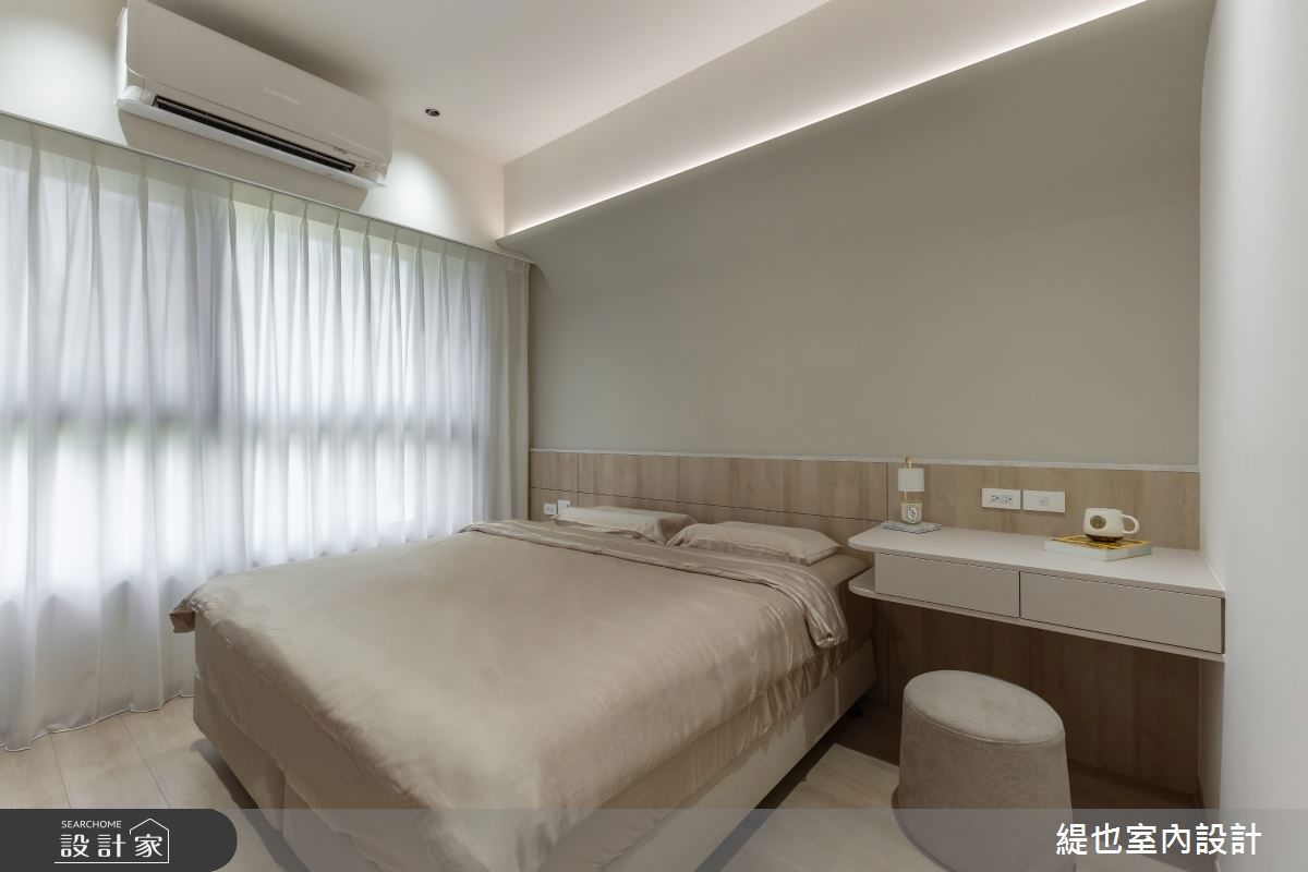 主臥以柔和霧鄉色營造溫暖休憩氛圍，床頭上方圓弧線條修飾大樑，化解風水疑慮
