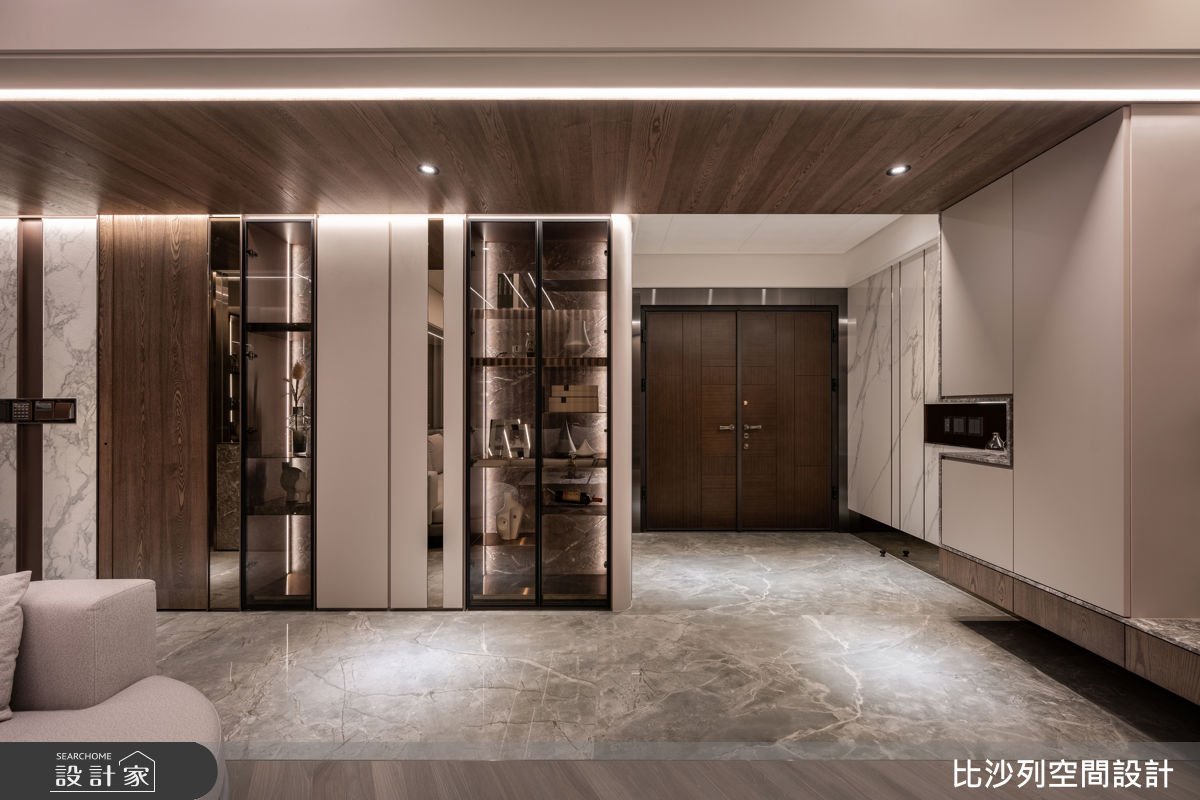  玄關以石紋、鏡面與金屬描邊，入門即建立氣勢，並導入整體材質語言。