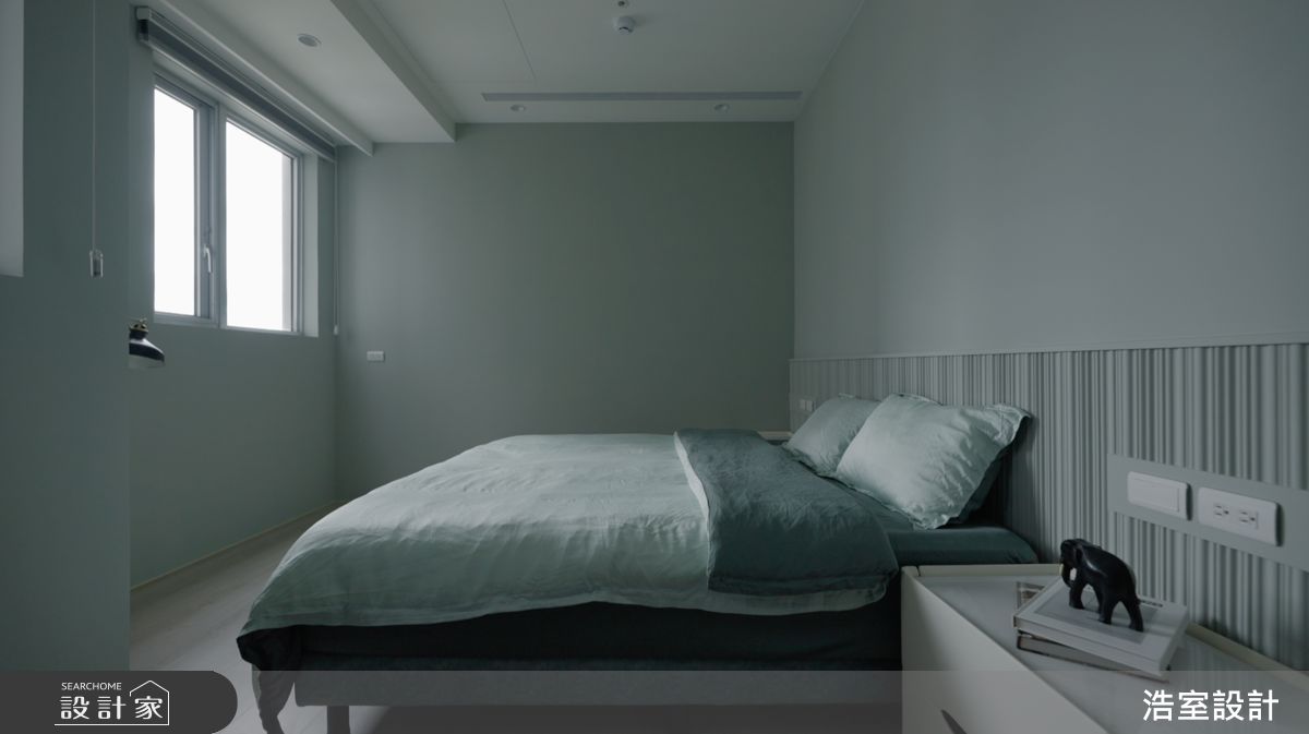 次臥床頭採木質格柵造型，呈現舒適與安定的氛圍。