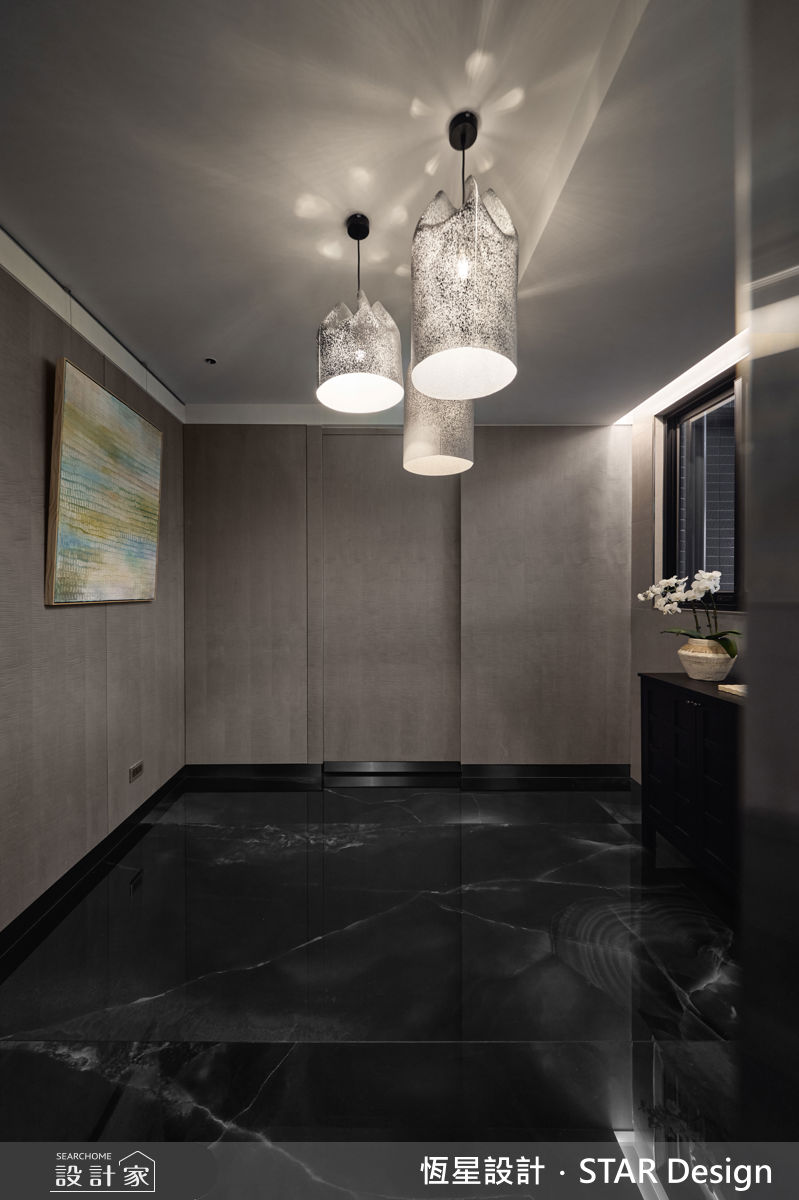 梯廳玄關透過深色石紋鋪陳，並規劃藝術迎賓區，創造強烈的視覺印象。