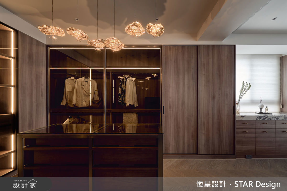 更衣室以木質色系鋪陳，搭配藝術造型吊燈，展現靜謐奢華的氛圍。