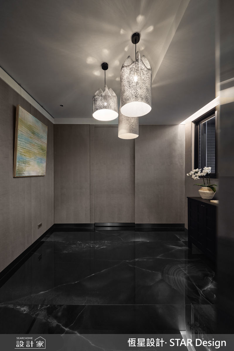 梯廳玄關透過深色石紋鋪陳，並規劃藝術迎賓區，創造強烈的視覺印象。