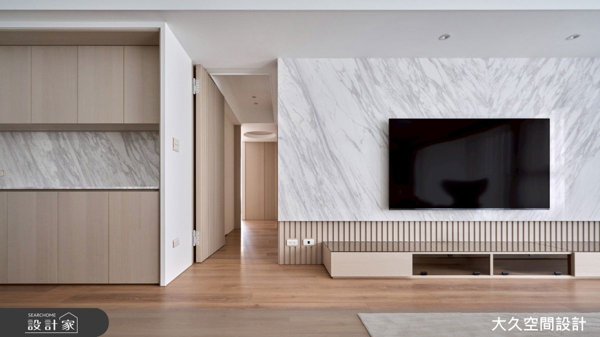 客廳電視牆以石材和格柵鋪陳，並規劃集線收納櫃，保持整潔空間。