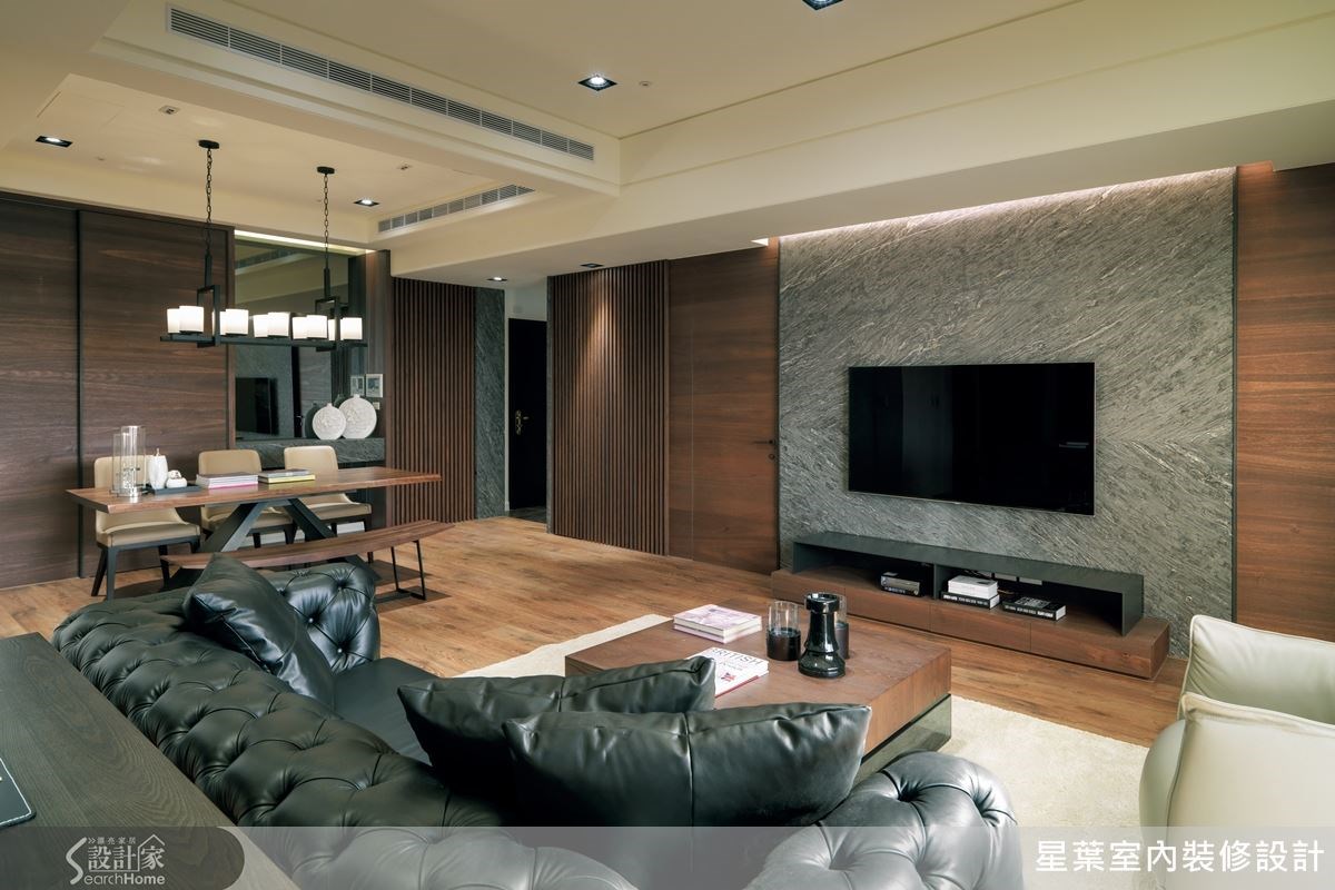 以消光灰階石材打造的電視主牆,上緣深入天花板與兩側包框手法,緩解了材質厚重感,同時也以木質格柵陪襯,讓視覺豐富有層次。 以消光灰階石材打造的電視主牆,上緣深入天花板與兩側包框手法,緩解了材質厚重感,同時也以木質格柵陪襯,讓視覺豐富有層次。