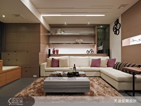 設計師為客廳空間創造豐富的收納機能,而沙發背牆則以凹槽打造出展示櫃體,讓屋主可以自由擺放心愛的收藏或照片。 設計師為客廳空間創造豐富的收納機能,而沙發背牆則以凹槽打造出展示櫃體,讓屋主可以自由擺放心愛的收藏或照片。