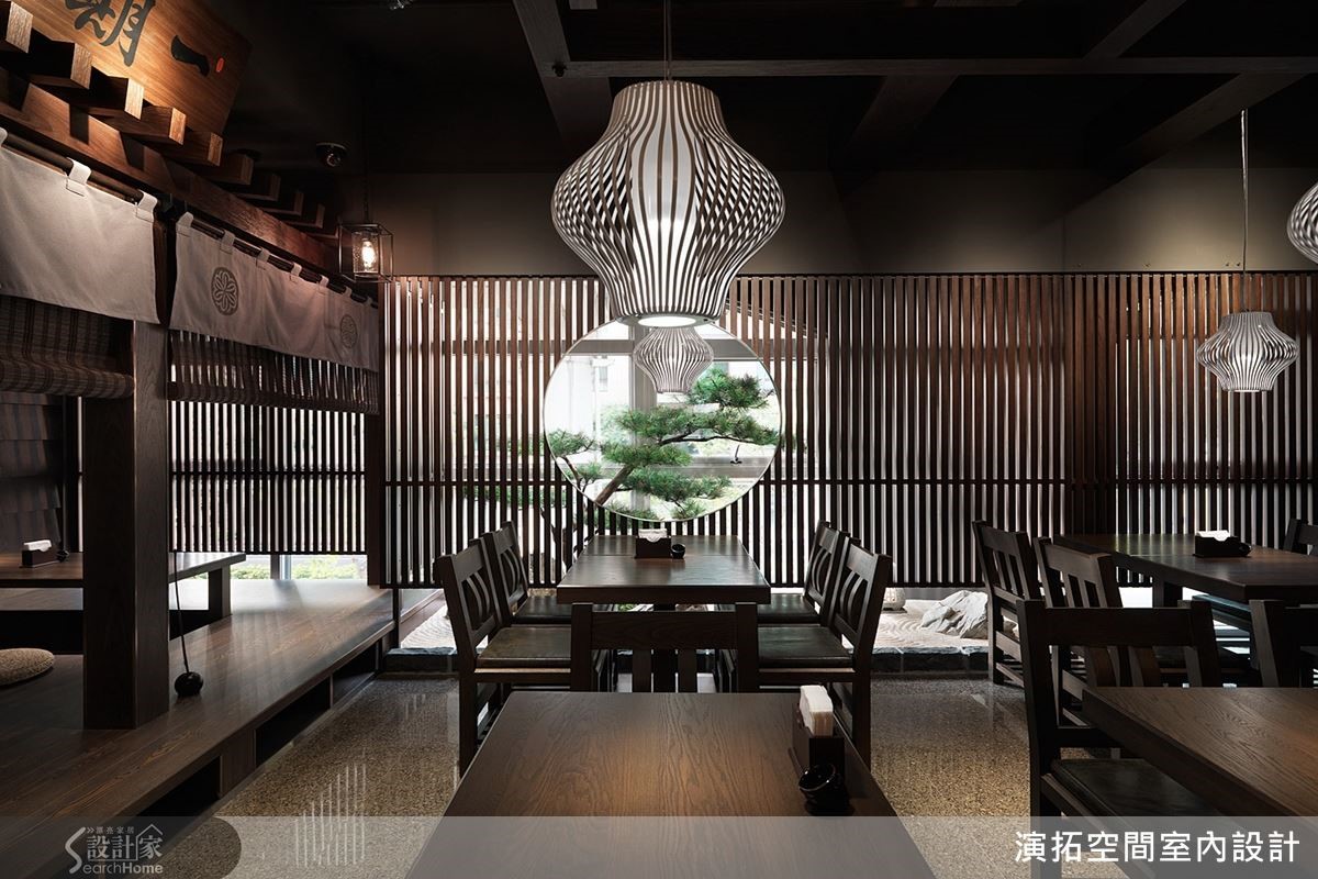 以深色木材質、圓窗格柵與燈光展現日式雅韻。窗外枯山水庭院造景,結合原石、沙畫,在寧靜中隱藏些趣味性。 以深色木材質、圓窗格柵與燈光展現日式雅韻。窗外枯山水庭院造景,結合原石、沙畫,在寧靜中隱藏些趣味性。