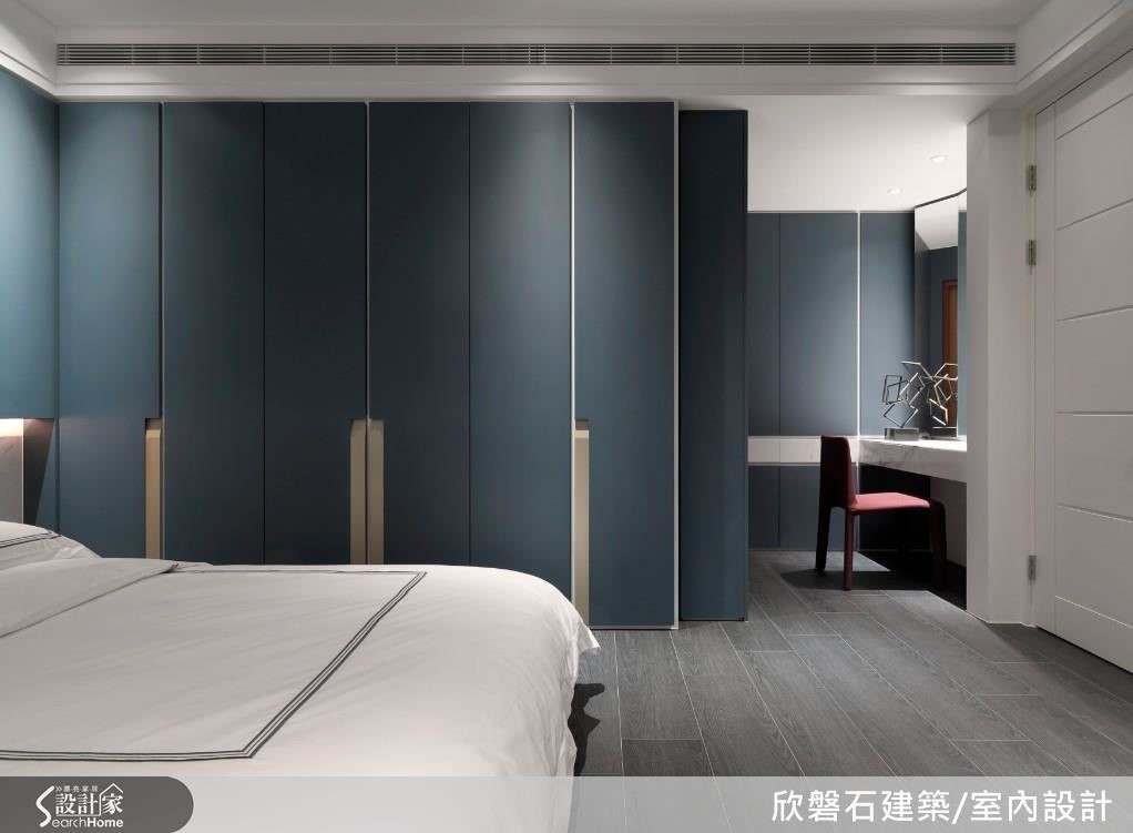 次臥以樑化出小客廳中起居與書房場域,整面白色拉門隱藏了以畸零角落建構的吧檯與收納空間,釋放視覺感受退以室外綠意景致為主角。睡眠區以白色大理石為底衍生懸空床頭櫃,立面承載搭配烤漆金隱藏式把手設計的墨藍色烤漆櫃體,延伸入內,梳妝區以卡拉拉白銀狐石材腰帶設計裝飾,石材導角抽屜與隱藏式鏡子,呈現細緻工藝與色彩的美學構思。 次臥以樑化出小客廳中起居與書房場域,整面白色拉門隱藏了以畸零角落建構的吧檯與收納空間,釋放視覺感受退以室外綠意景致為主角。睡眠區以白色大理石為底衍生懸空床頭櫃,立面承載搭配烤漆金隱藏式把手設計的墨藍色烤漆櫃體,延伸入內,梳妝區以卡拉拉白銀狐石材腰帶設計裝飾,石材導角抽屜與隱藏式鏡子,呈現細緻工藝與色彩的美學構思。