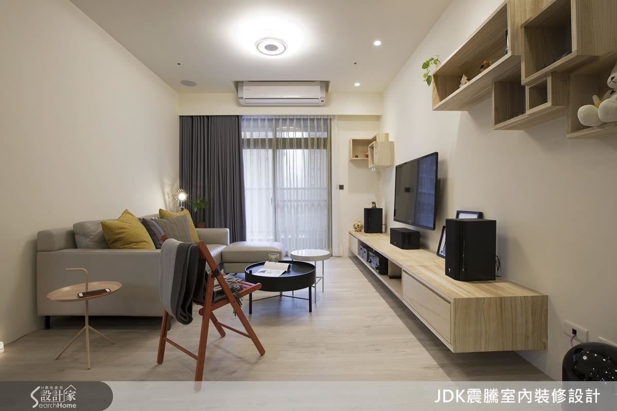 讓出部分空間給主臥的客廳小巧玲瓏,喜愛極簡風的業主不想要過多的裝飾,於是震騰團隊以擅長的幾何造型做出數個小巧的吊櫃搭配,呼應電視櫃的梧桐木設計,呈現一致性的質樸美感。 讓出部分空間給主臥的客廳小巧玲瓏,喜愛極簡風的業主不想要過多的裝飾,於是震騰團隊以擅長的幾何造型做出數個小巧的吊櫃搭配,呼應電視櫃的梧桐木設計,呈現一致性的質樸美感。