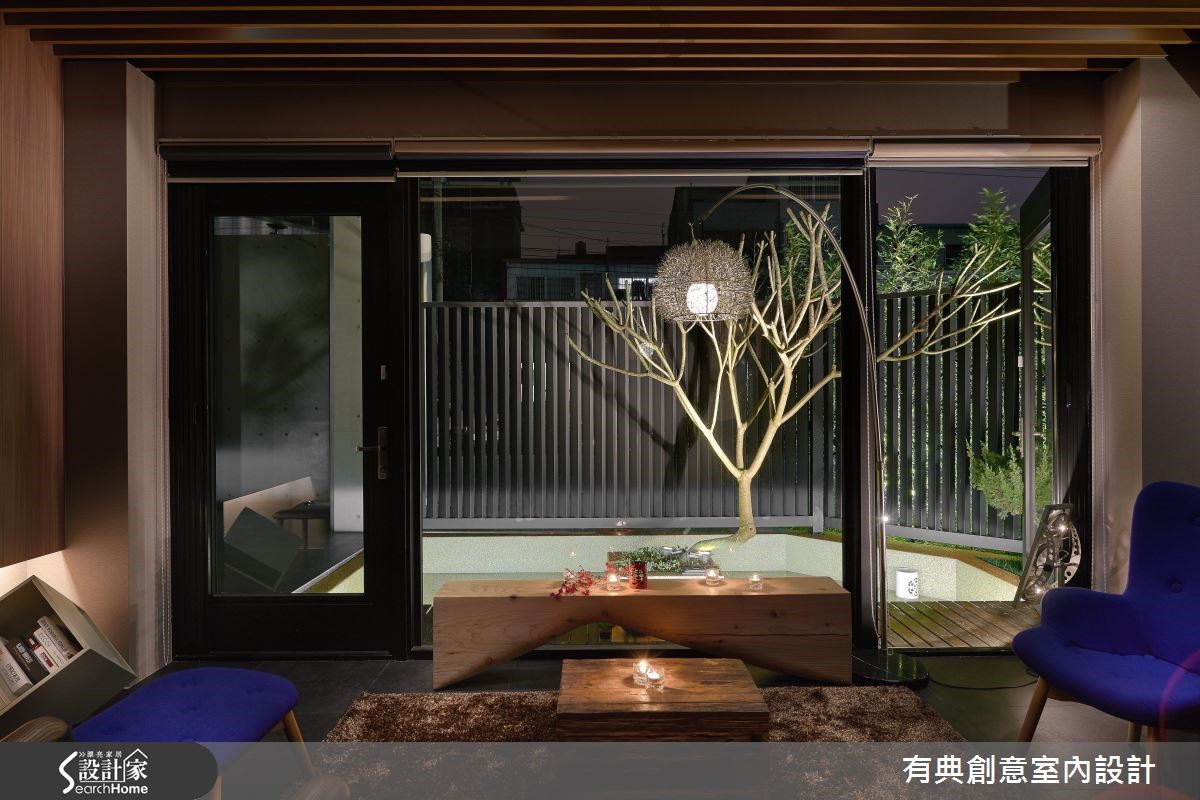 大門口的建築物外觀以清水模打造,一旁飾以稀疏的綠意
