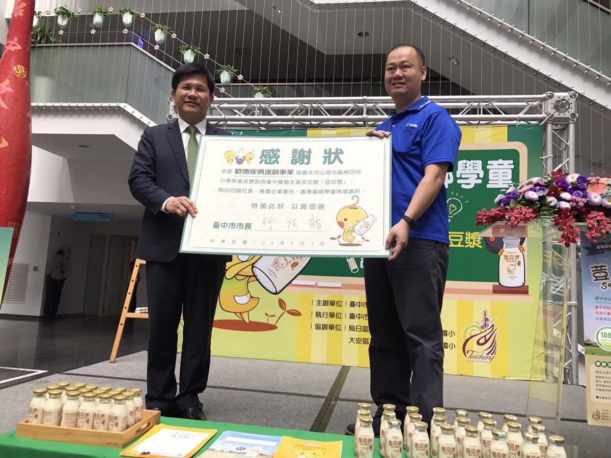 台中市府媒合企業認養國產非基改豆漿,歐德集團率先響應,台中市市長林佳龍頒贈感謝狀予歐德集團總經理陳國甫。 台中市府媒合企業認養國產非基改豆漿,歐德集團率先響應,台中市市長林佳龍頒贈感謝狀予歐德集團總經理陳國甫。