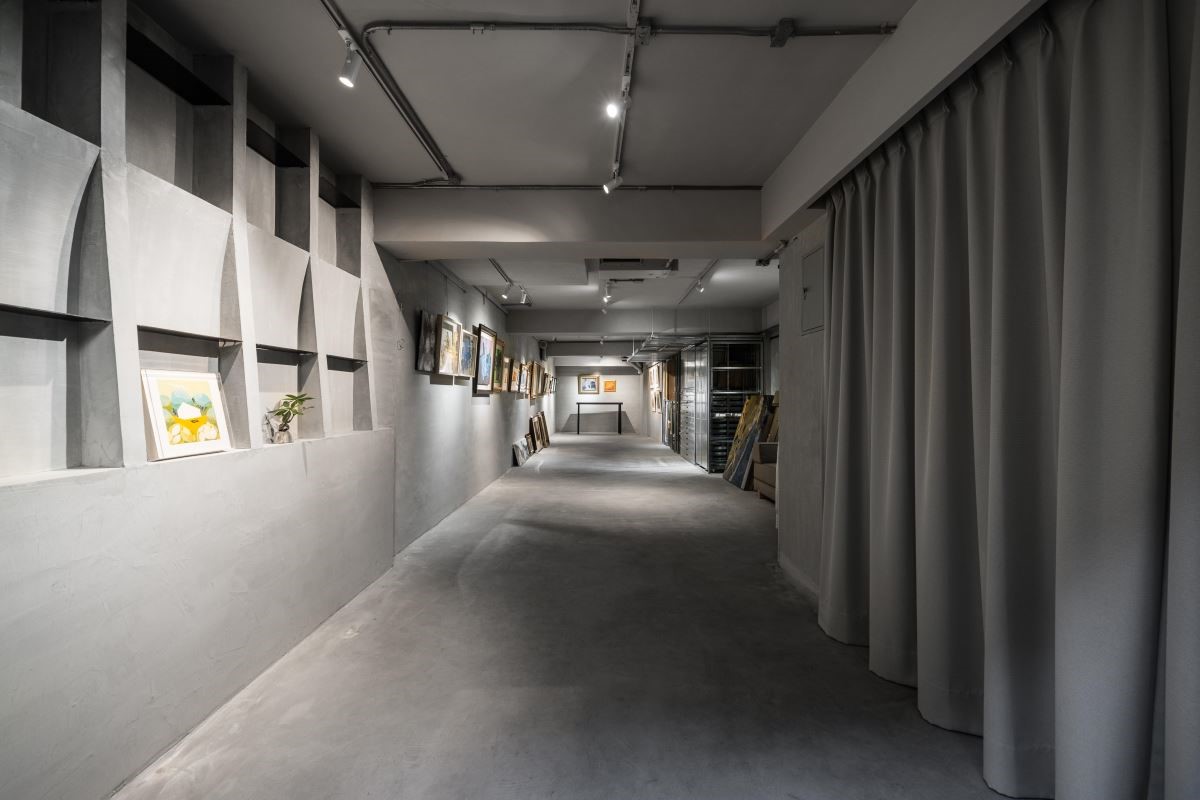 地下室畫廊以格狀展示櫃賦予空間機能,並考量光線投射於畫作的聚焦性,選用水泥鋪陳牆面避免反光的視覺問題。 地下室畫廊以格狀展示櫃賦予空間機能,並考量光線投射於畫作的聚焦性,選用水泥鋪陳牆面避免反光的視覺問題。