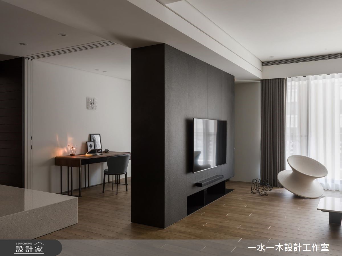 運用線條簡單的深黑電視櫃將空間一分為二,界定公、私