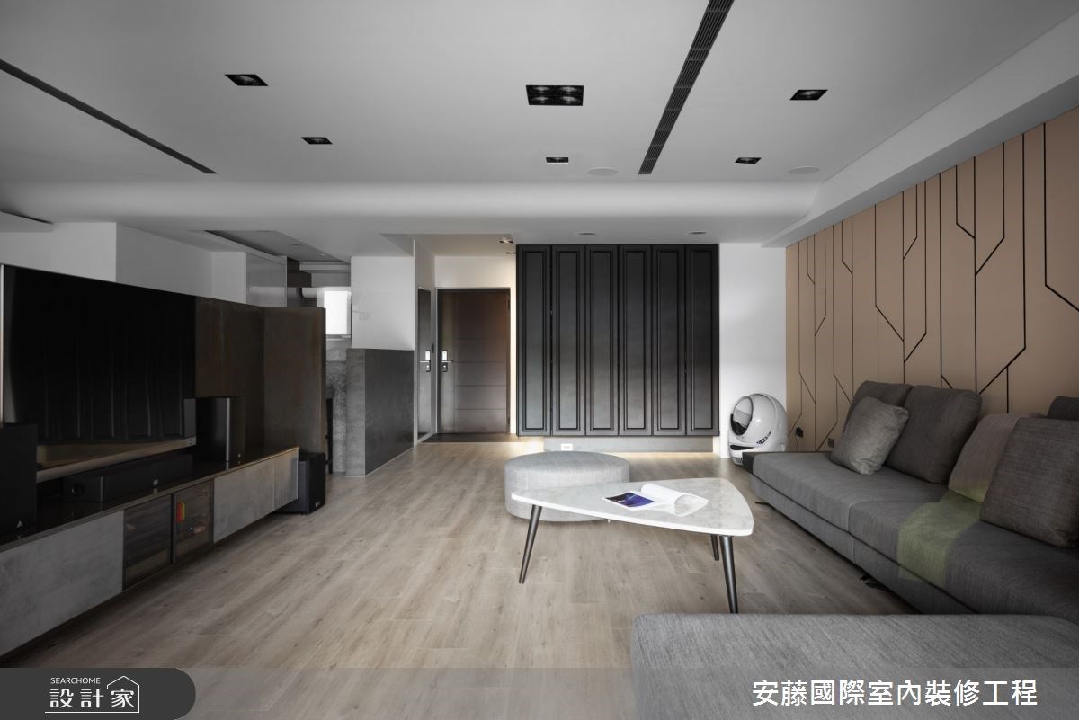 公領域內,以溫潤木地板鋪陳,對比俐落線性的沙發背牆