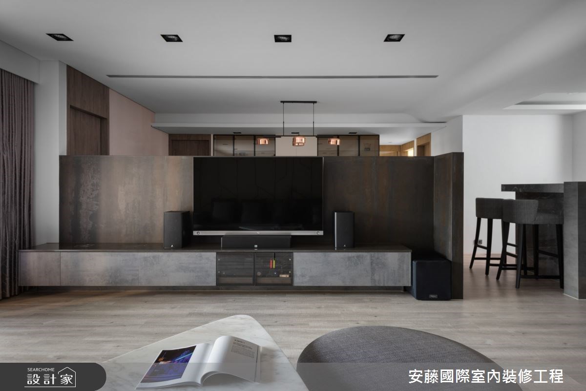 公領域內,以溫潤木地板鋪陳,對比俐落線性的沙發背牆