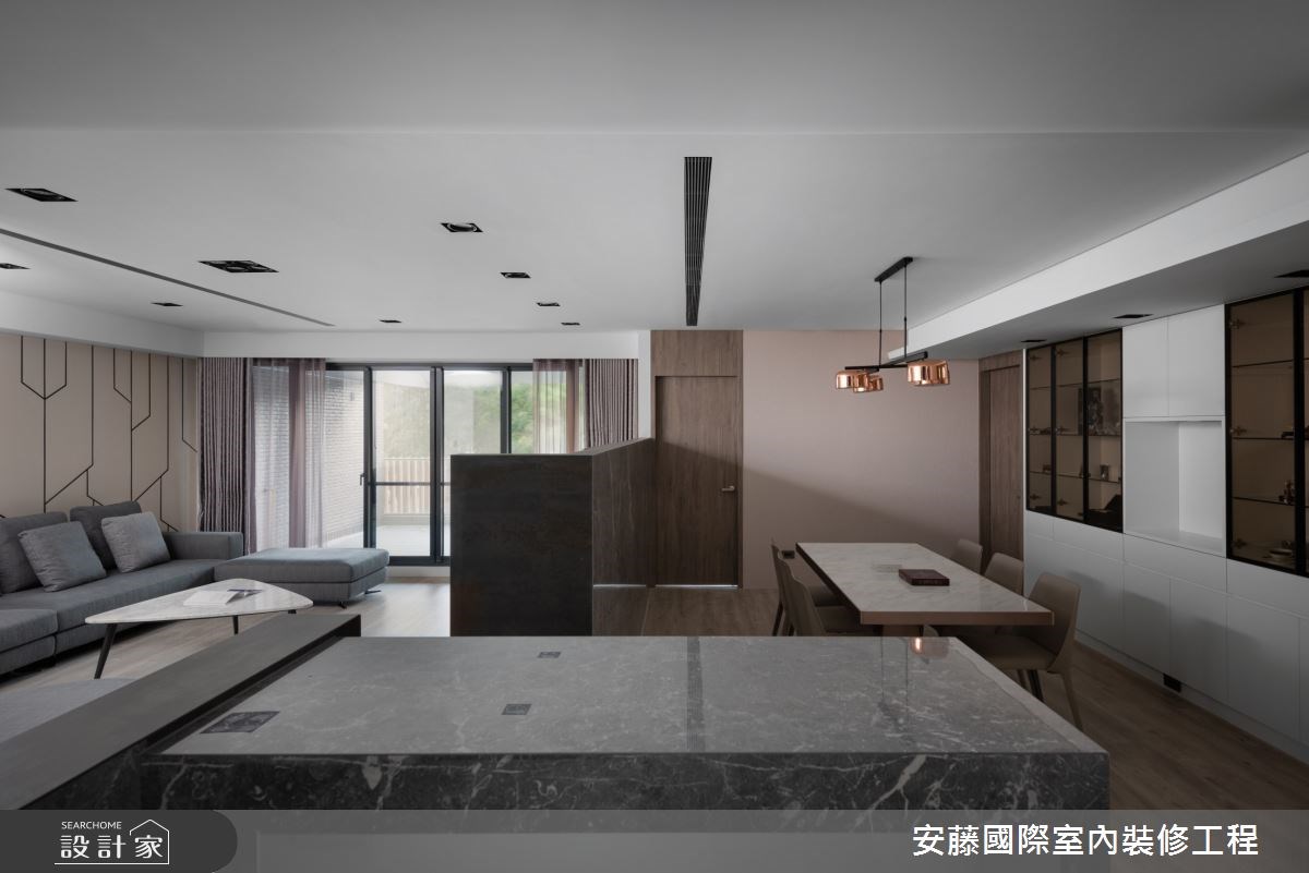 公領域內,以溫潤木地板鋪陳,對比俐落線性的沙發背牆