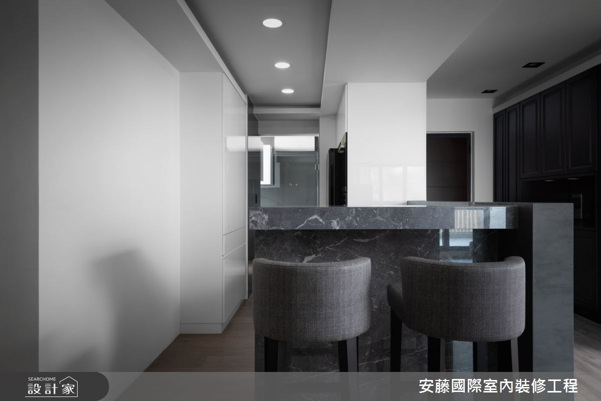 公領域內,以溫潤木地板鋪陳,對比俐落線性的沙發背牆