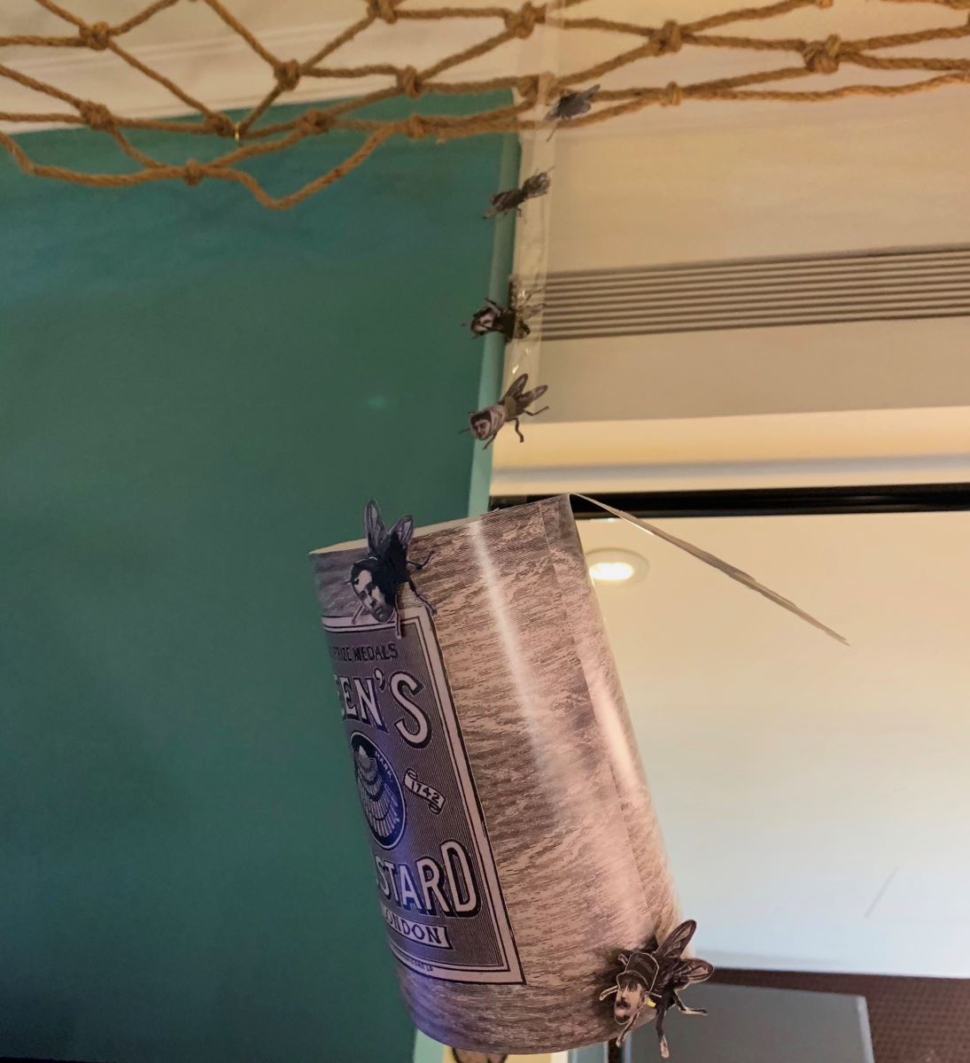 牆上裝置以未清洗的罐頭作為觀眾對馬戲團戲法的著迷,被膠帶黏住的人頭蒼蠅隱喻為受困於馬戲團中的團員,為了生存付出巨大的代價。 牆上裝置以未清洗的罐頭作為觀眾對馬戲團戲法的著迷,被膠帶黏住的人頭蒼蠅隱喻為受困於馬戲團中的團員,為了生存付出巨大的代價。