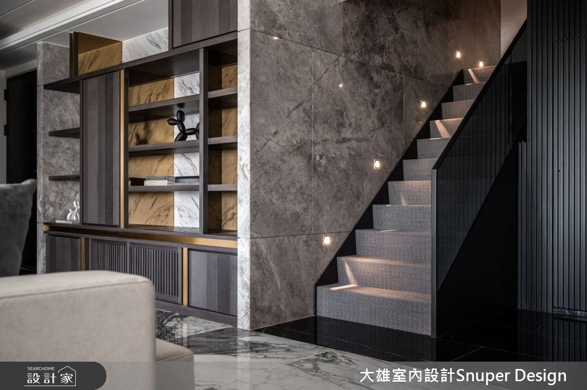 玄關區以深色石材鋪設地坪,石材壁面的局部以內凹設計