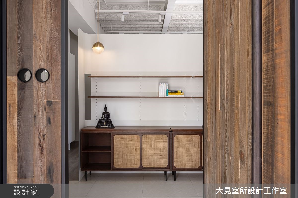 復古磨石建築外觀的複層建築外圍繞著大型落地植物,一