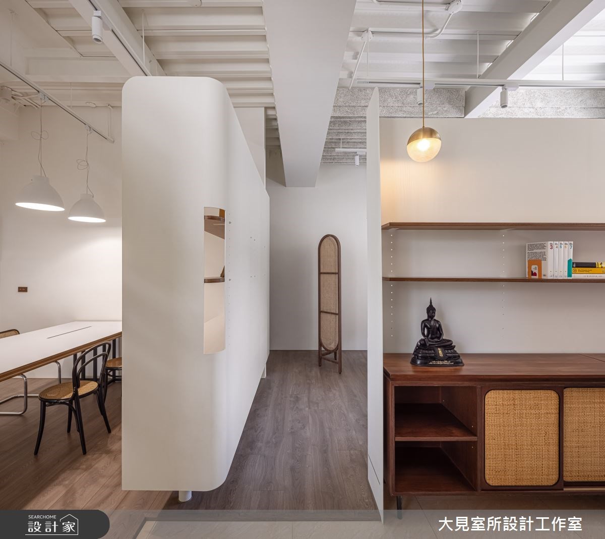 復古磨石建築外觀的複層建築外圍繞著大型落地植物,一