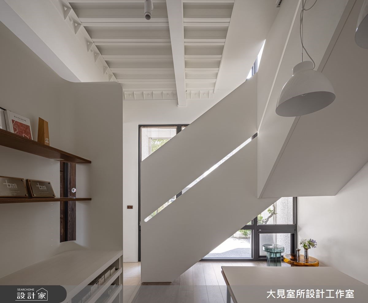復古磨石建築外觀的複層建築外圍繞著大型落地植物,一