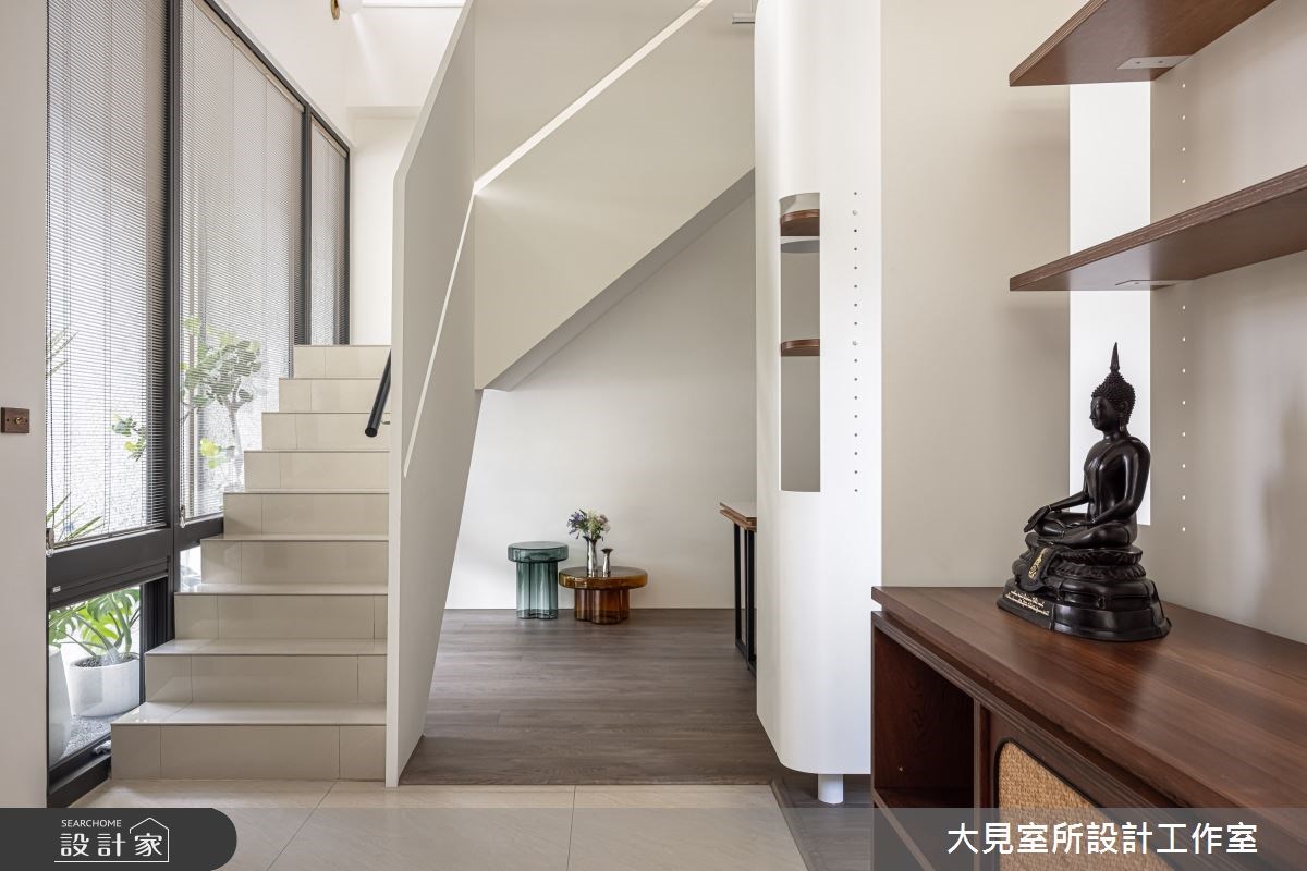 復古磨石建築外觀的複層建築外圍繞著大型落地植物,一