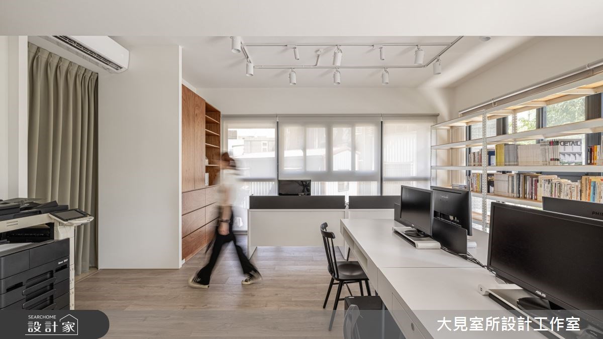 復古磨石建築外觀的複層建築外圍繞著大型落地植物,一