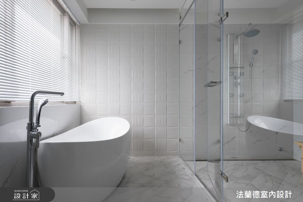 在簡潔明亮的全白色系浴室，兼顧實用與美感做出變化，牆面的白磚有凹槽紋，以紋路的方向性交錯變化貼磚，地板使用大理石紋路的長磚做斜四十五度貼磚，低調中的細節都是設計巧思。
